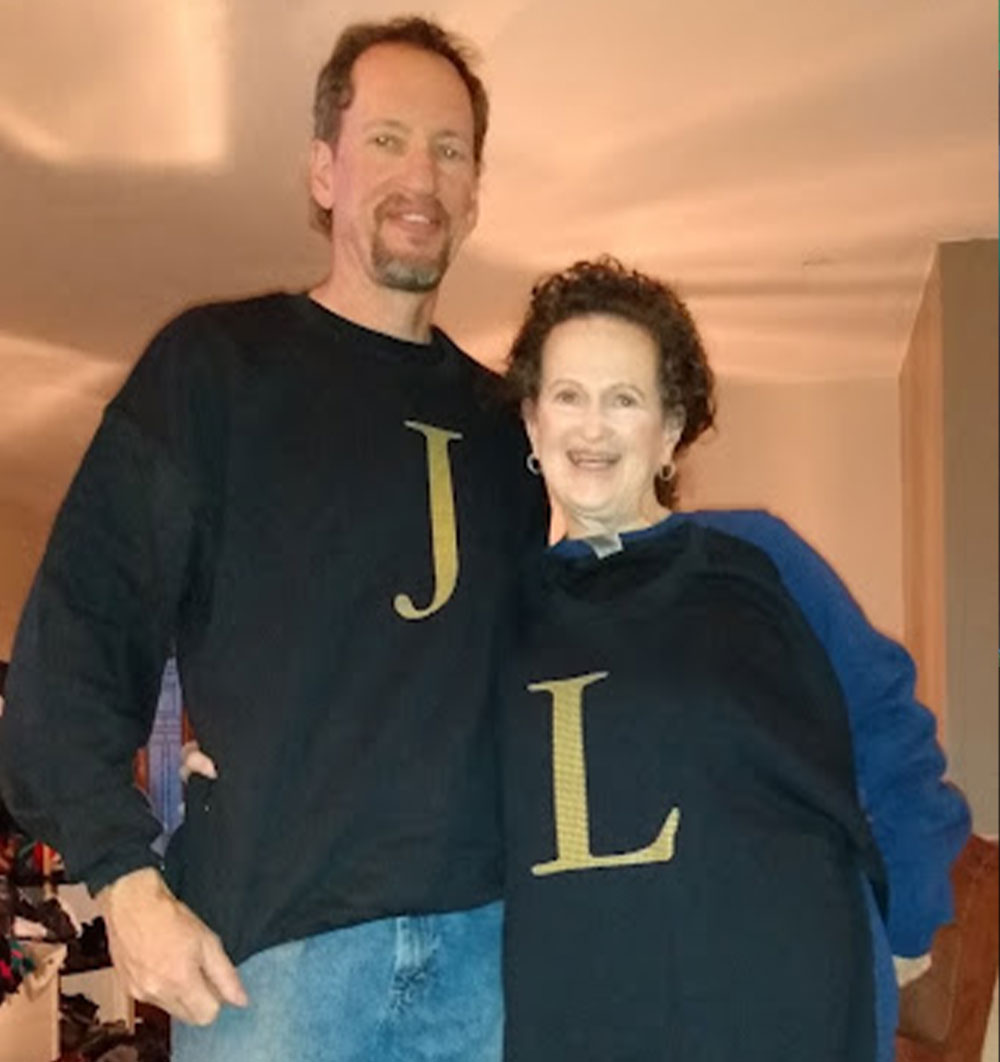 Linda and John, showing off their “L” and “J” sweaters, respectively, at John’s house, Christmas 2021