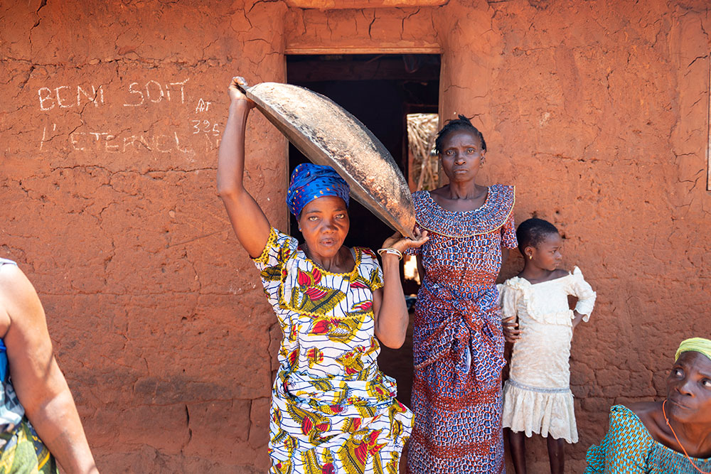 Adjoa carrying a large bowl on her shoulder after her life-changing cleft surgery