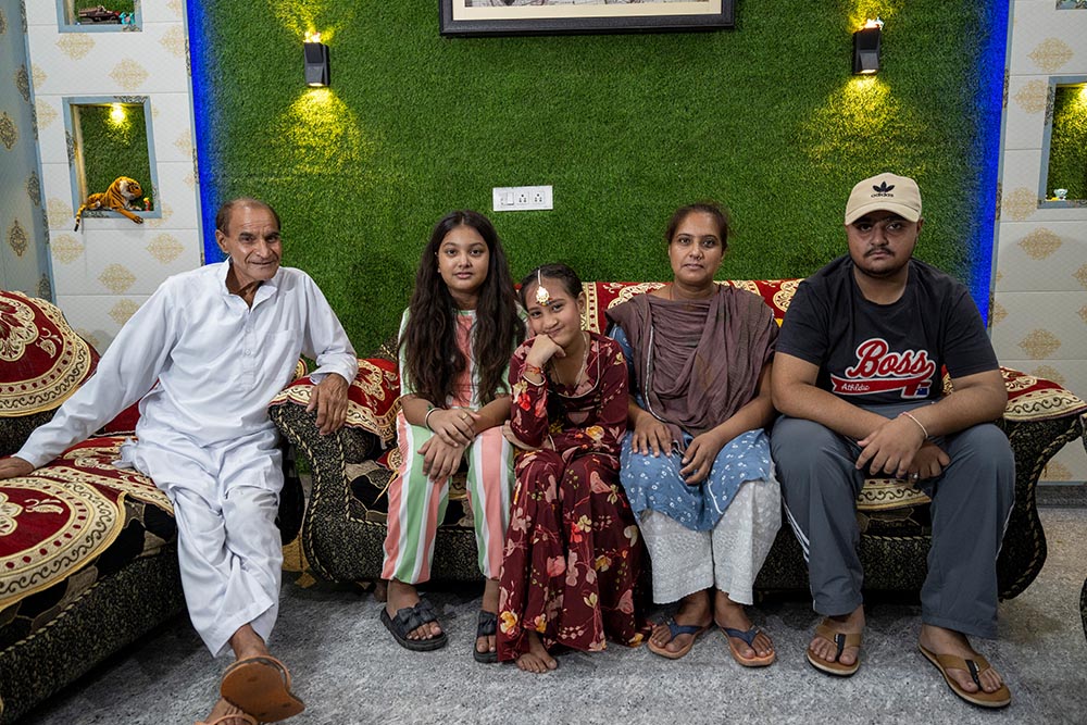 Bhumika smiling with her grandfather, sister, mother Jyoti and brother and sitting after cleft surgery