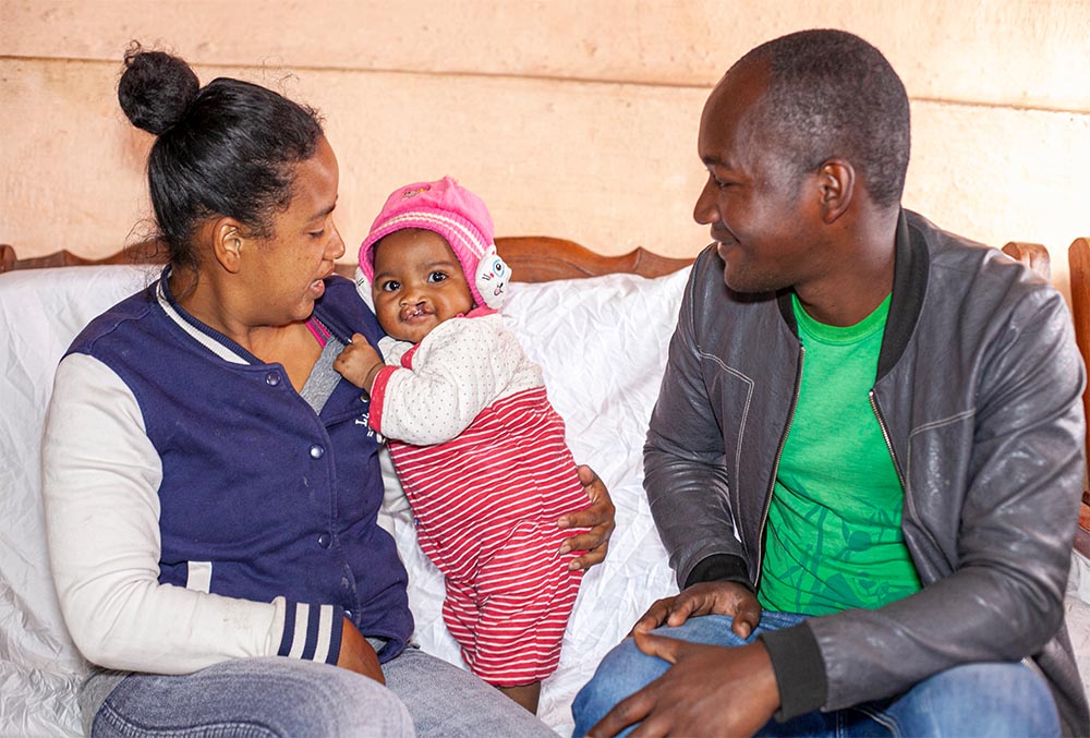 Tsiorihasina before cleft surgery standing between her parents