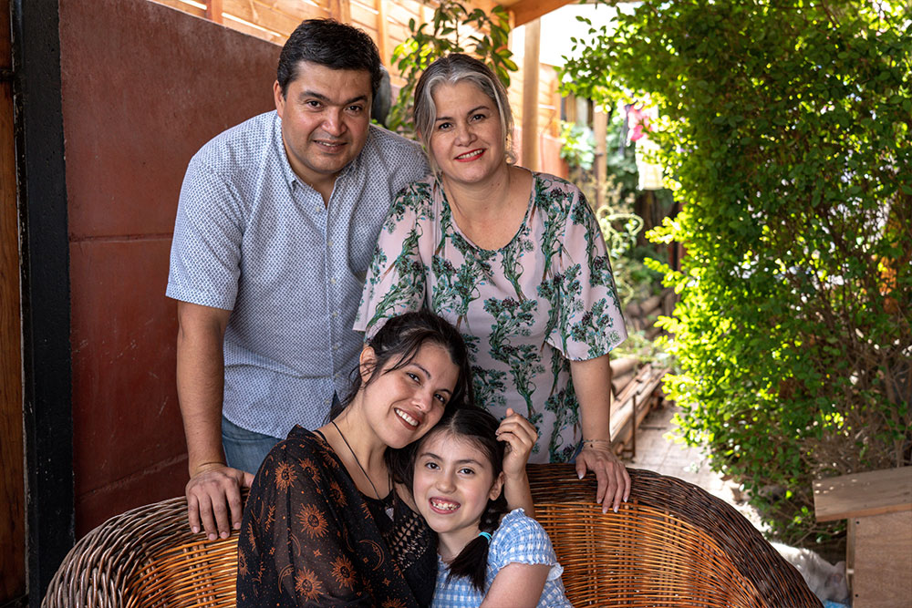 Amelie smiling and hugging her mother, father and grandmother after cleft surgery