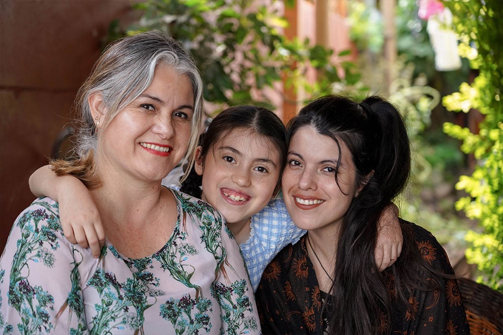 Amelie smiling with her mother and grandmother after cleft surgery