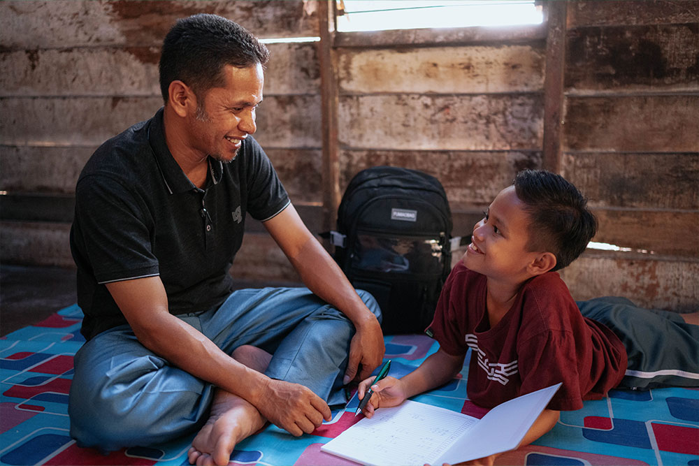 Zafran smiling with his dad Yustiwizarto after cleft surgery