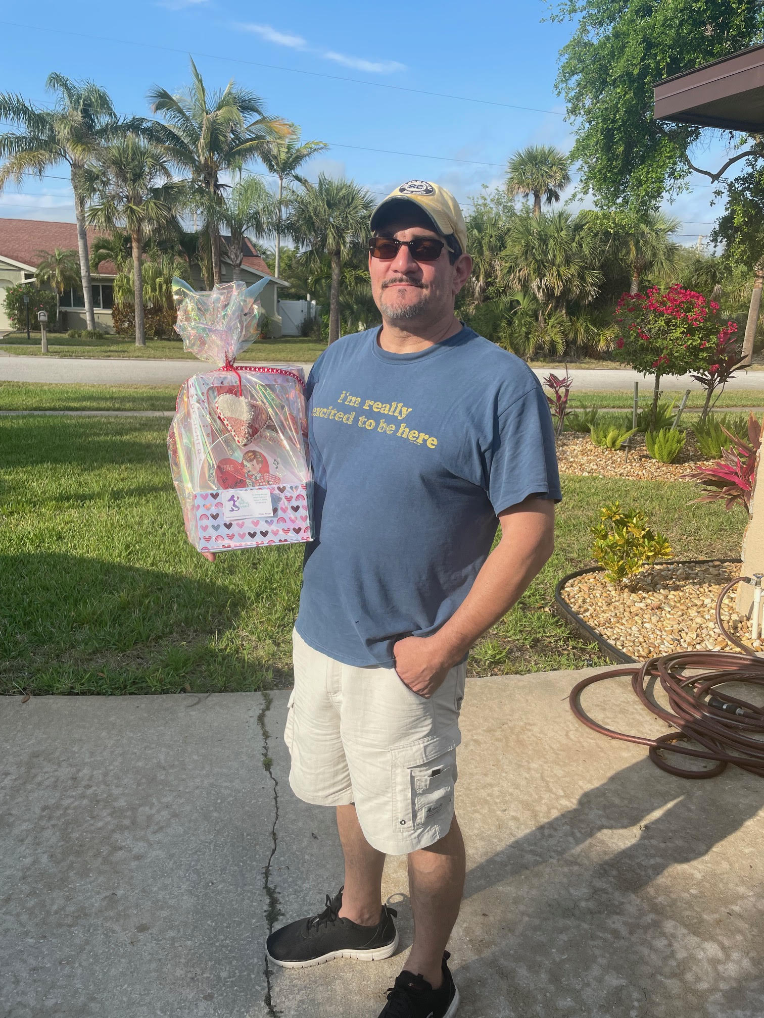 A man outside holding a Valentine’s Day-themed gift basket