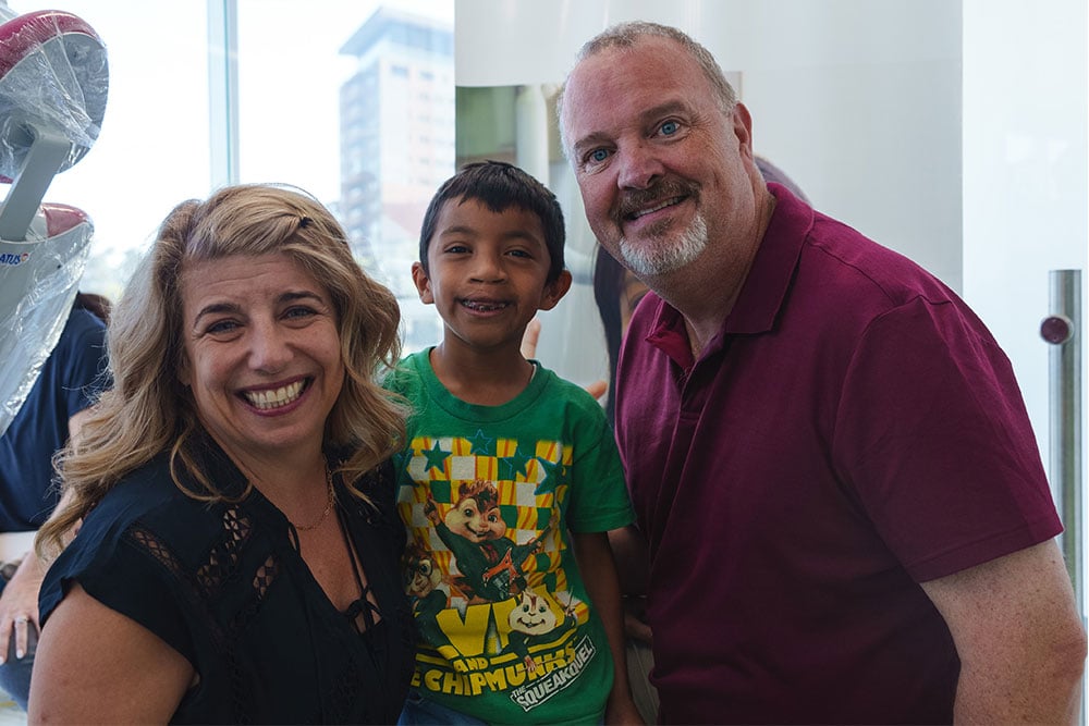 Seth and Becca share a smile with a Smile Train patient