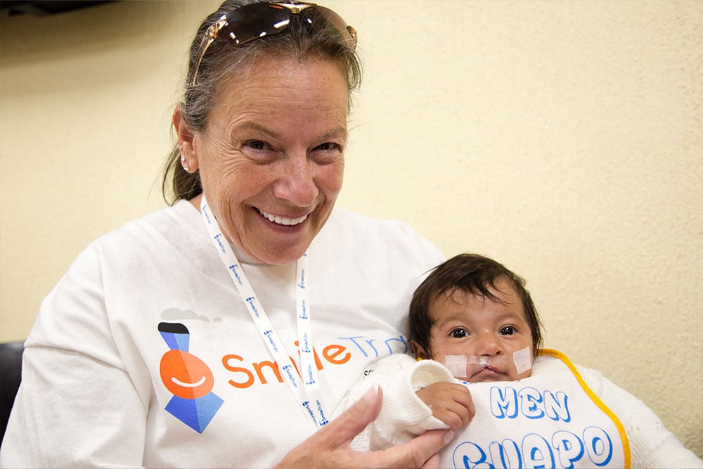 Karen holding a baby just before cleft surgery
