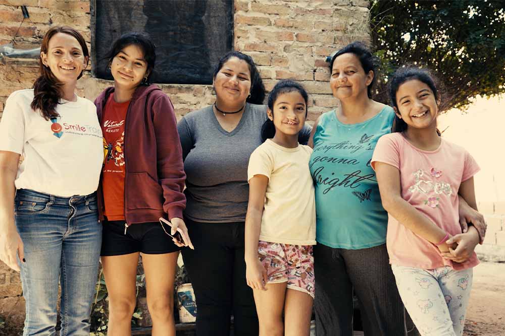 Victoria with her mother, two of her sisters, and a Smile Train employee