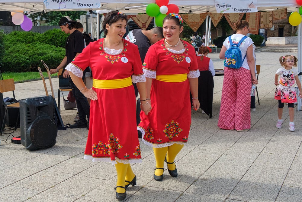 Two women dancing in traditional Bulgarian dress