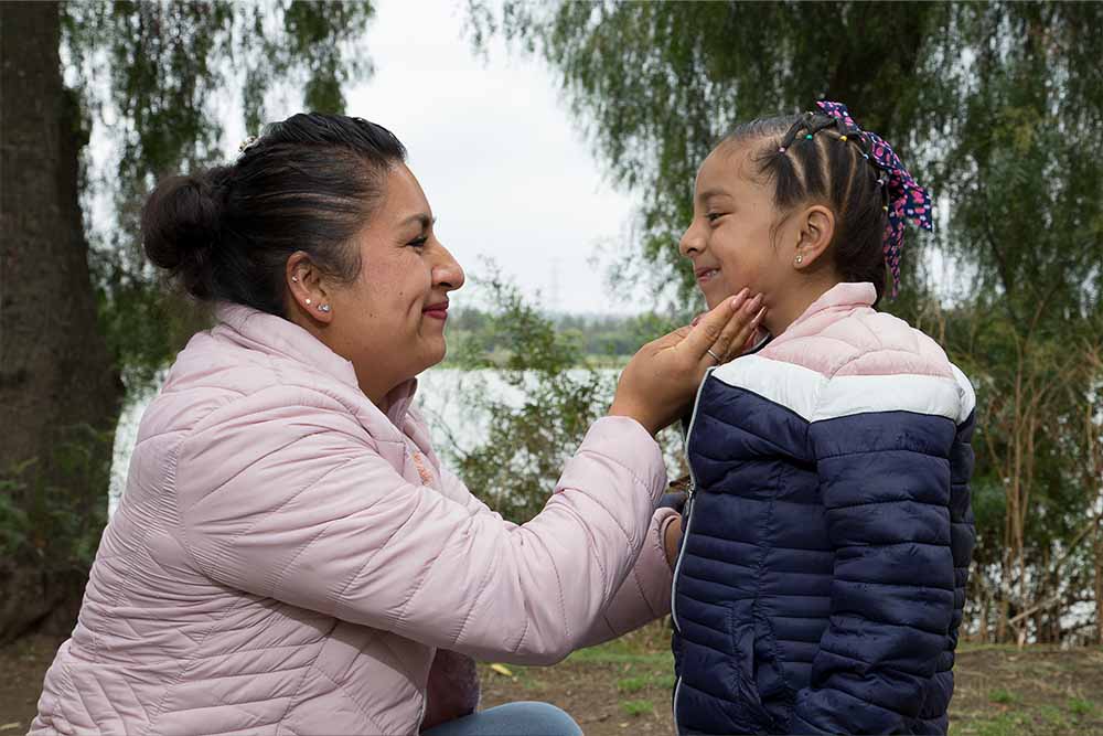 In profile, Leticia and Ivanna smile at each other widely
