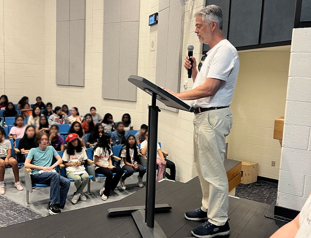 Mr. Fontaine addressing the students. Many are wearing Smile Train shirts