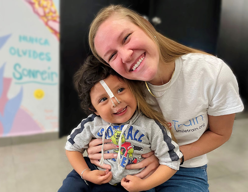 Sara hugging and smiling with a patient