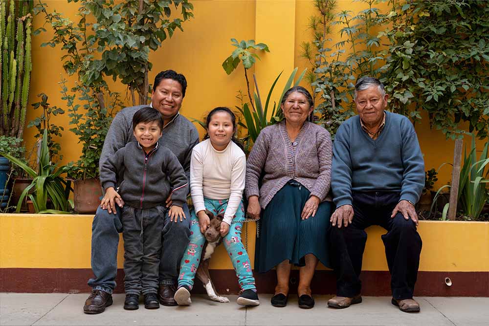 Daniel, Rene, Anahí and the kids’ grandparents sit and smile for a family picture