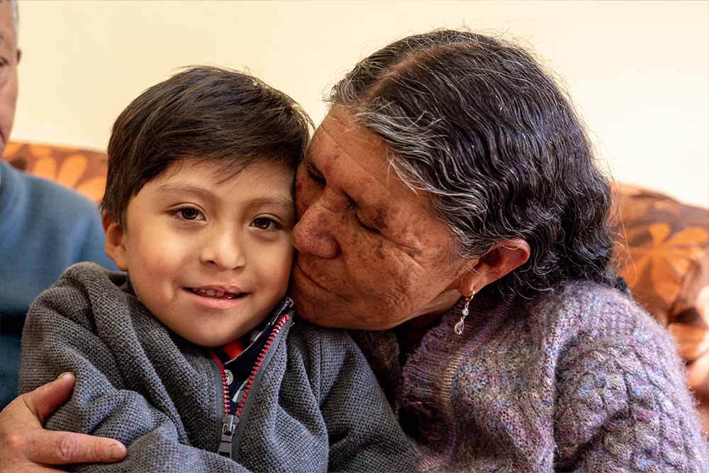 Daniel’s grandmother hugs him cheek to cheek