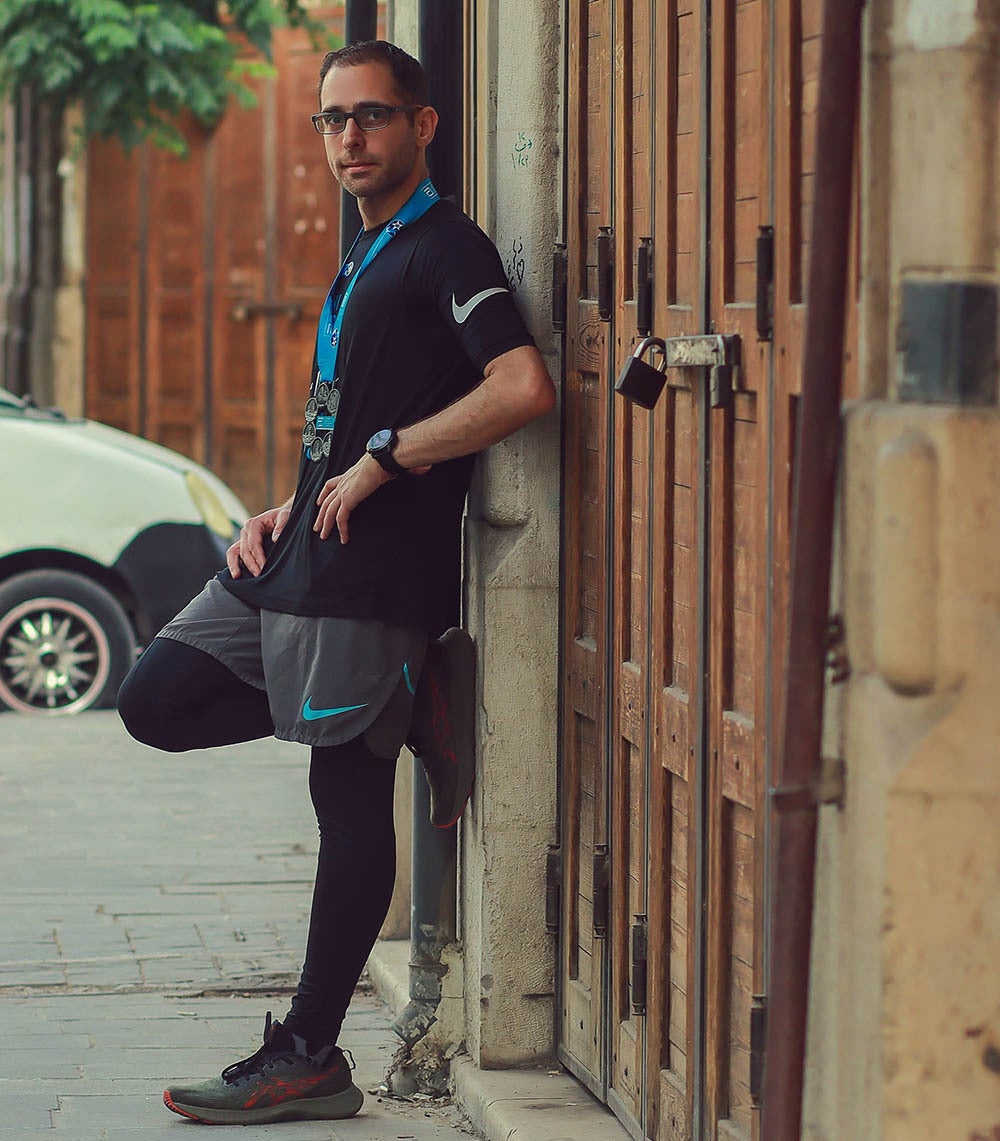 Al with his six World Marathon Majors medals standing in the street in the Old City of Damascus