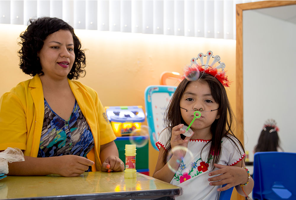 Barbara blows bubbles during Smile Train-sponsored speech therapy.