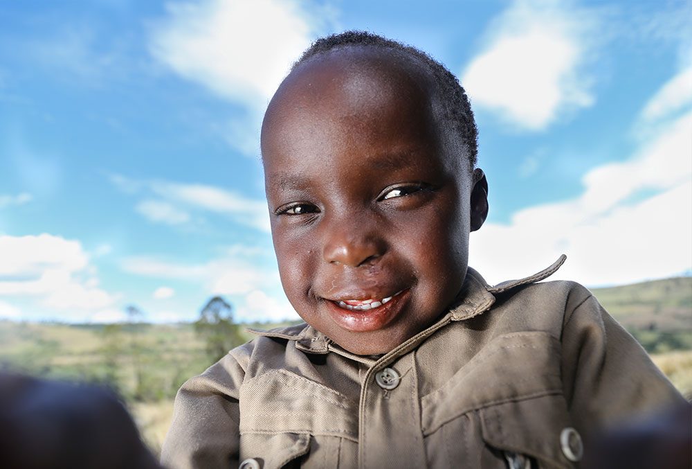 Benjamin smiling outside after his Smile Train-sponsored cleft surgery