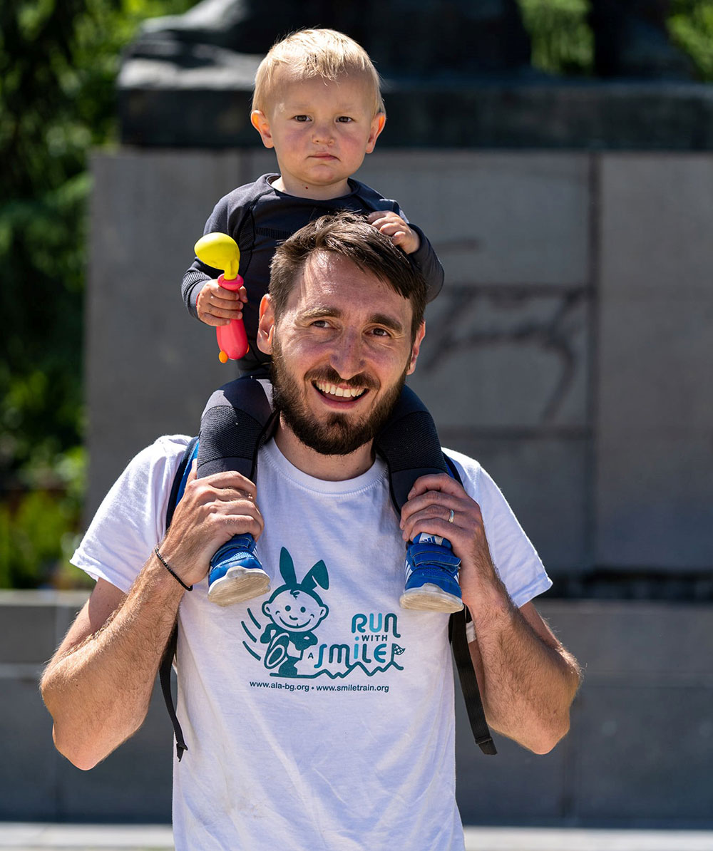 Metodi Simeonov holds Lev on his shoulders at the Run for Smiles in Vratsa, Bulgaria