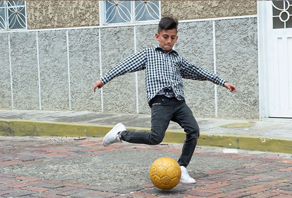 Cristian kicking a soccer ball
