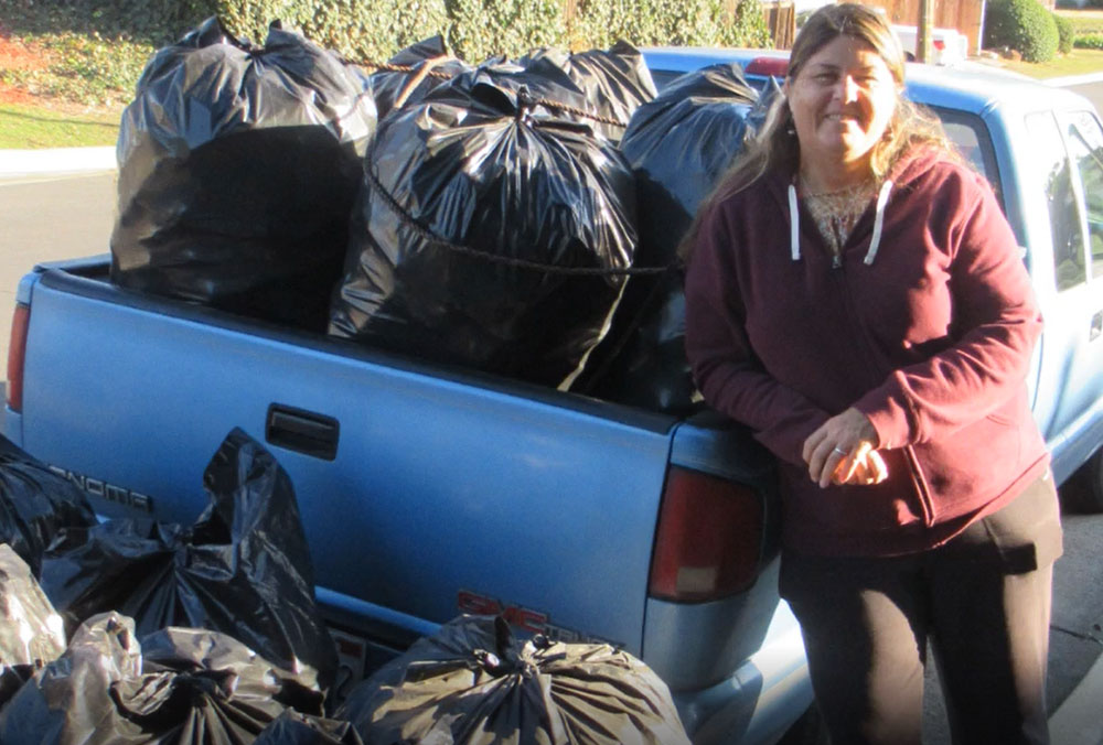 Dana loads bags of recycling onto a truck