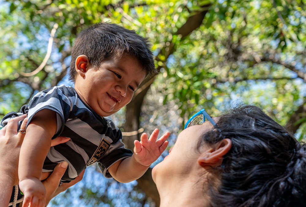 Felix's mother holds him in the air as he smiles after his free Smile Train-sponsored cleft surgery in Argentina