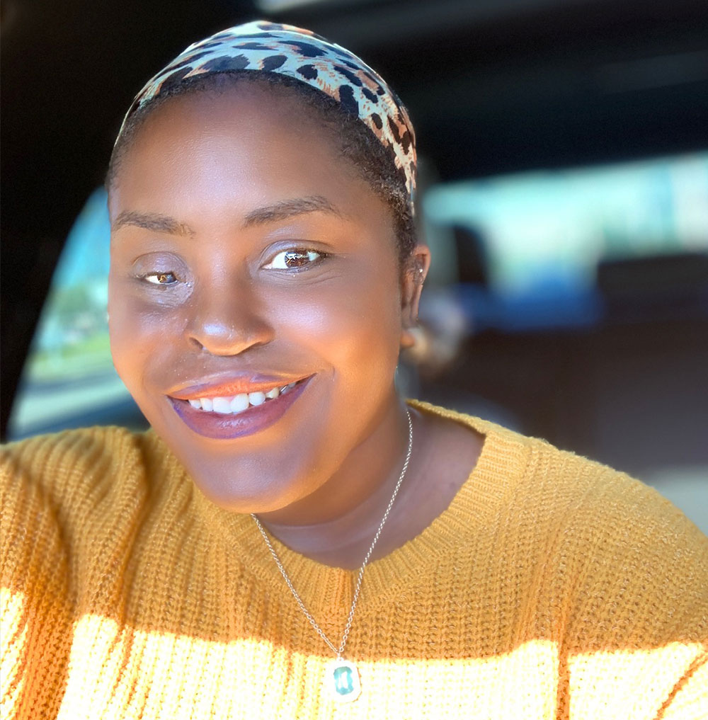 Iva smiling in her car.