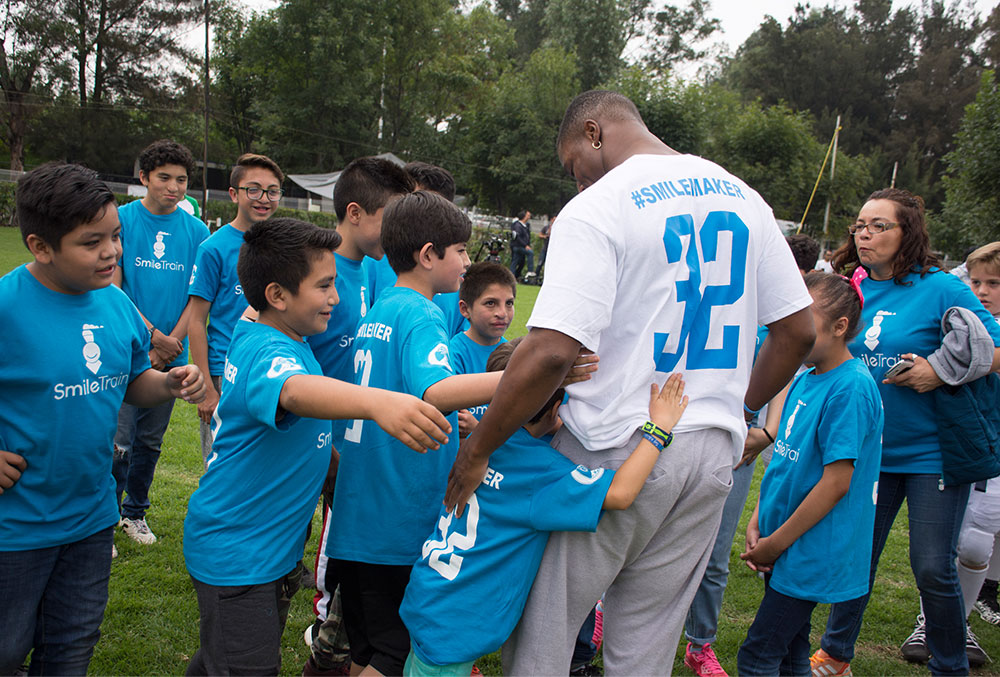 Kenyan Drake huddles with Smile Train cleft patients in Mexico