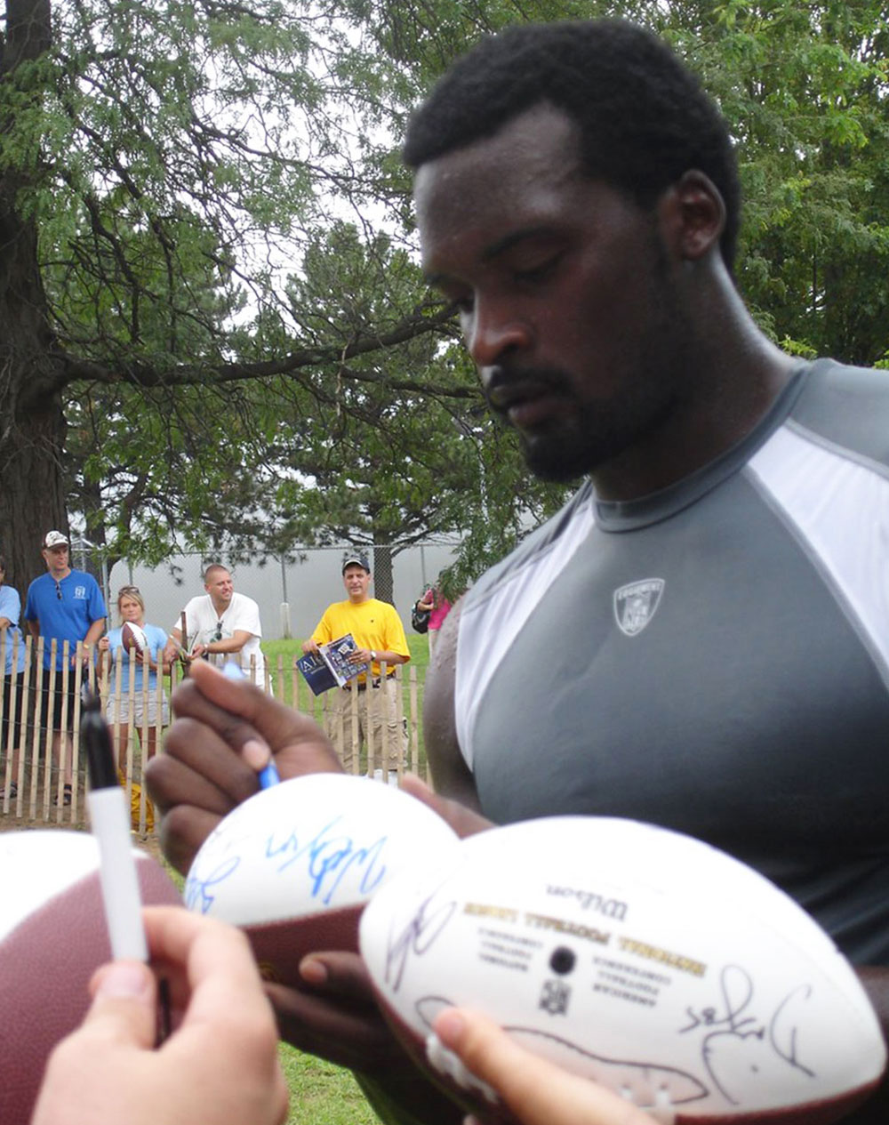 NY Giants' Mathias Kiwanuka signing footballs 