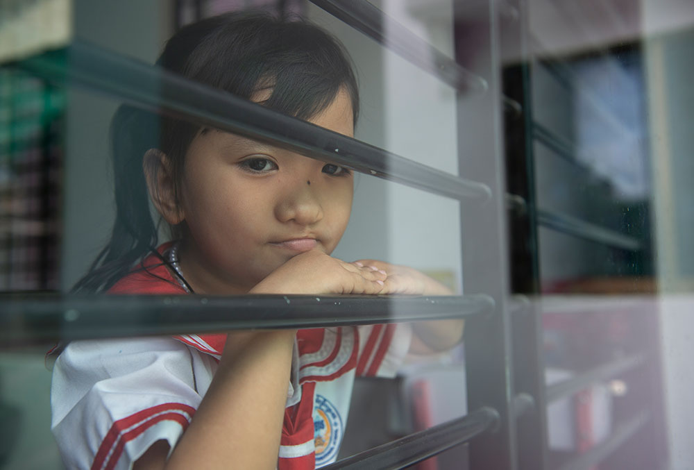 Meng looking out the window after her cleft lip and palate surgery.