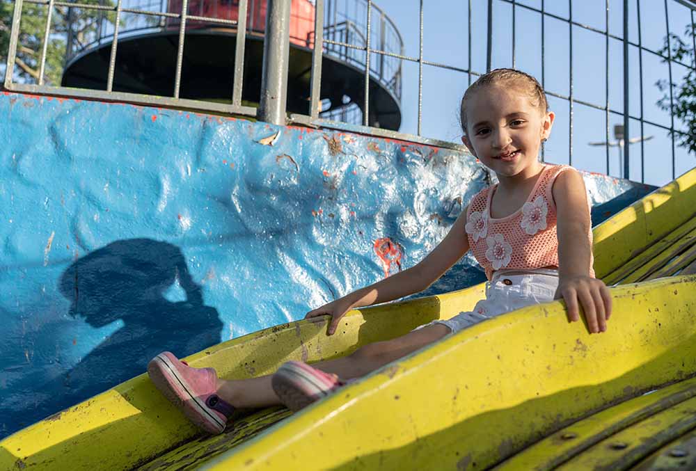 Mia going down playground slide