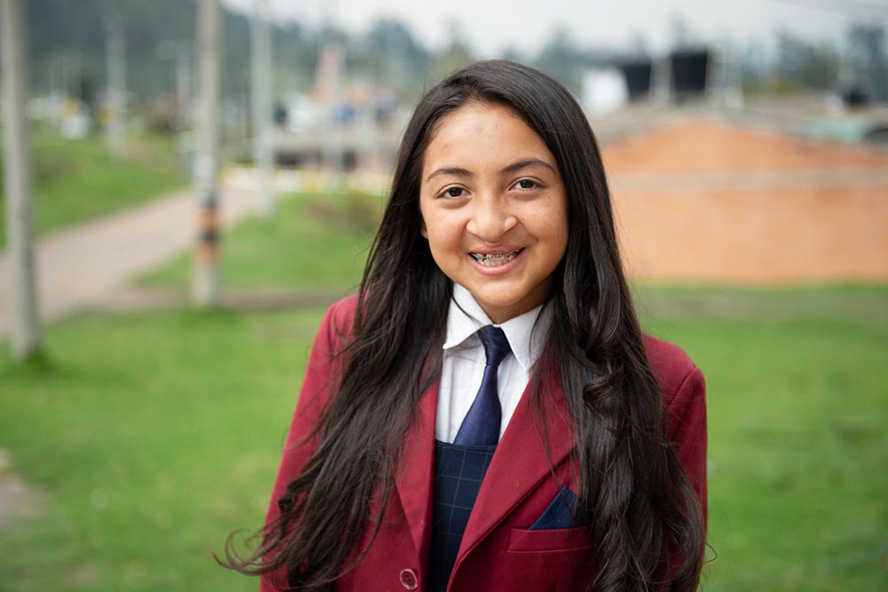 monica in school uniform waiting for school bus