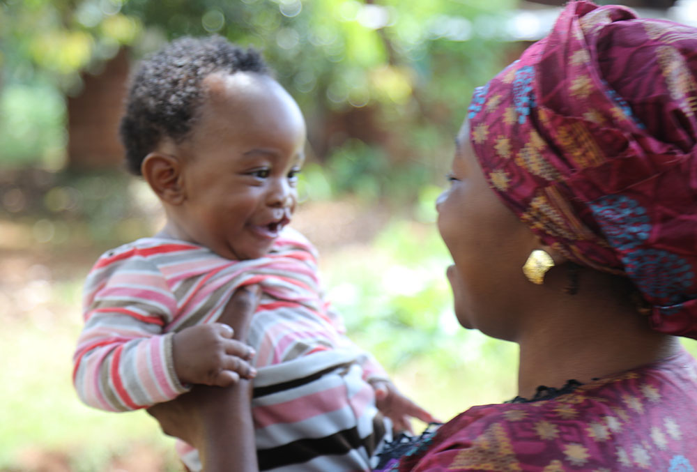 Mouhamed being held by his mother