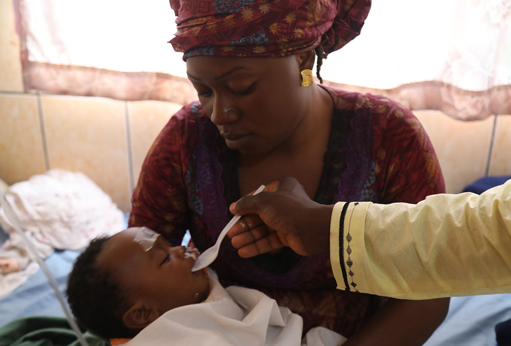 Mouhamed's mother feeding him after his cleft surgery