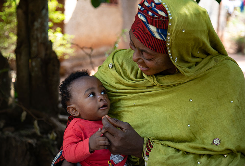 Mouhamed being held by his grandmother