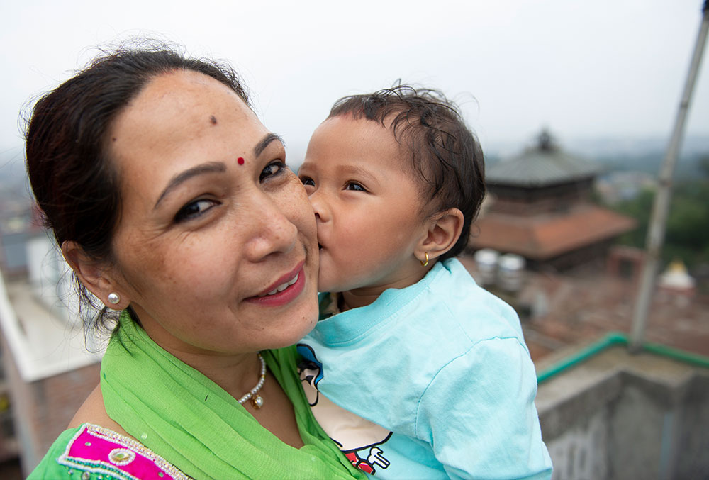 Mrighna kisses her mother after free Smile Train cleft surgery in Nepal