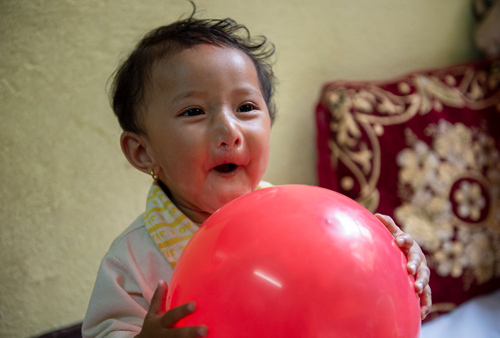 Mrighna holds a balloon and smiles after free Smile Train cleft surgery in Nepal