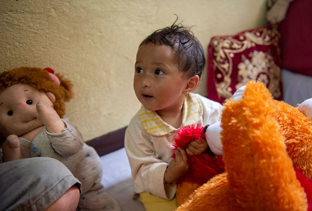Mrighna plays with a toy after free Smile Train cleft lip and palate surgery in Nepal