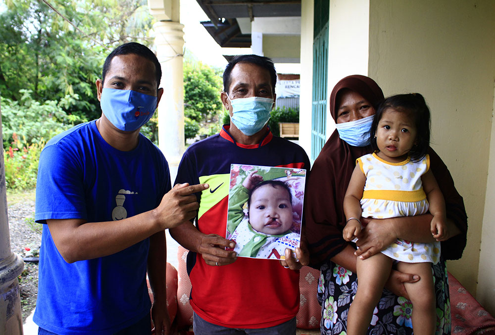 Rahmad with a family he connected with free cleft lip and palate in Indonesia