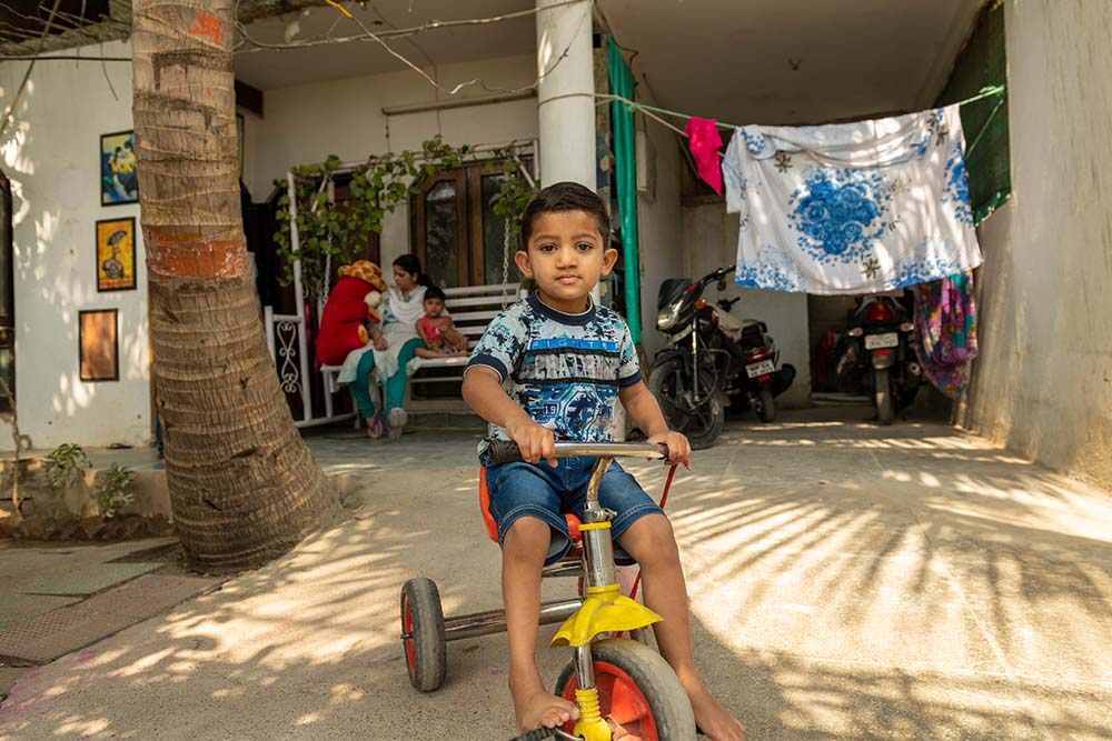 Saksham on his bike with family behind him