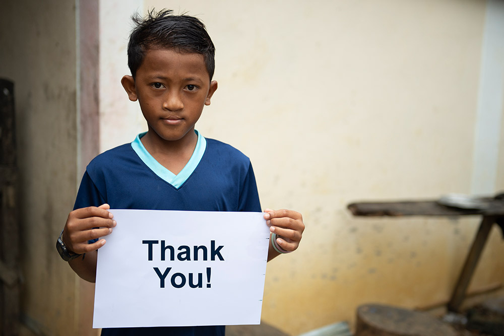 Sel holds a sign saying thank you