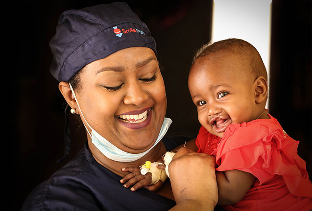 Sesnie holding a Smile Train patient after his cleft lip and cleft palate surgery in Ethiopia.