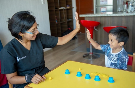 Speech therapy patient gives high five during session 