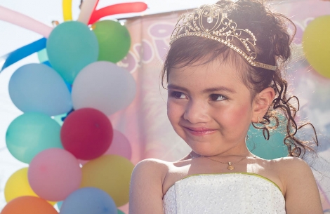 Alexa wearing her tiara and surrounded by colorful ballons