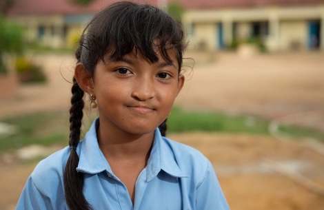 Samnang smiles in front of her school