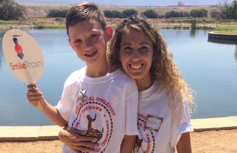 Krysta with her son holding a Smile Train sign