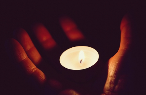 a hand holds a memorial candle