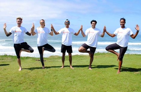 Group practicing yoga near ocean