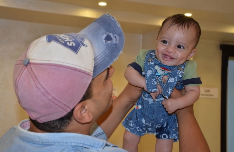 Saber being held by his father after his Smile Train cleft surgery