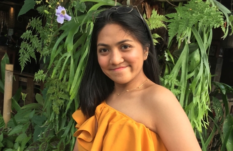 Jula smiling in front of some plants