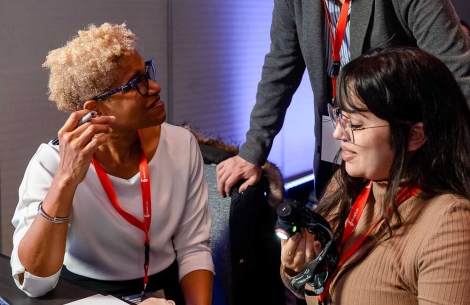 r. Judy Ward and another doctor sitting down with a Simulare cleft model on the table. They are talking to Dr. Juan Carlos Zambrano who is standing over them and leaning on their chairs.