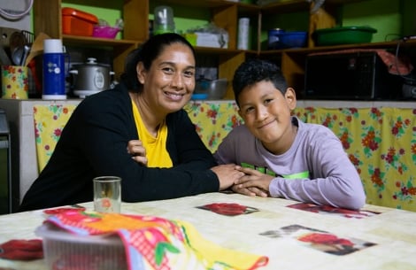 Carolina and Imanol sitting at the kitchen table holding hands